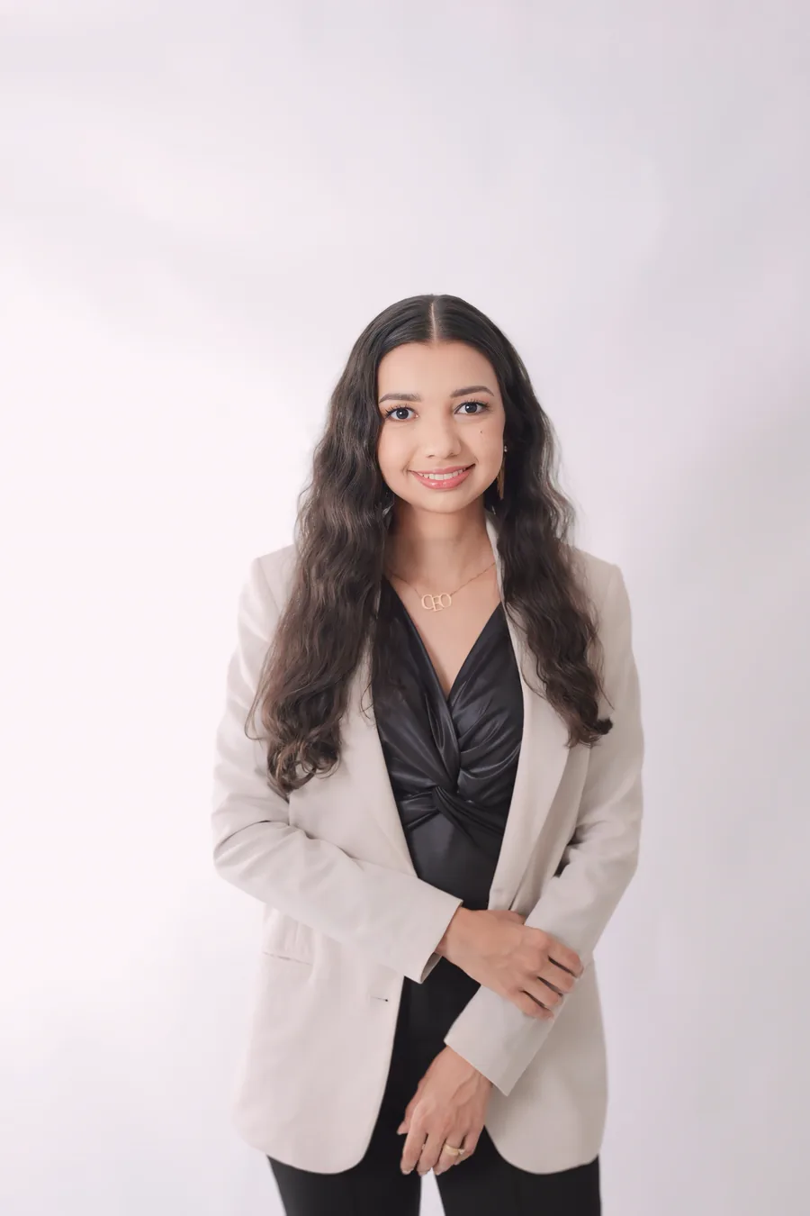 Retrato profissional de Bianca Melo, engenheira civil, de blazer claro sobre fundo branco.